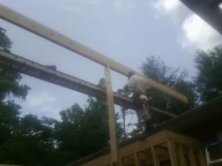 Carpenter setting a ridge beam over a new addition frame — Ice Dam Removal by Roofing Brothers in Low Moor