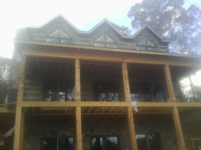 Dormers and porch framing on a large log home under construction in Low Moor