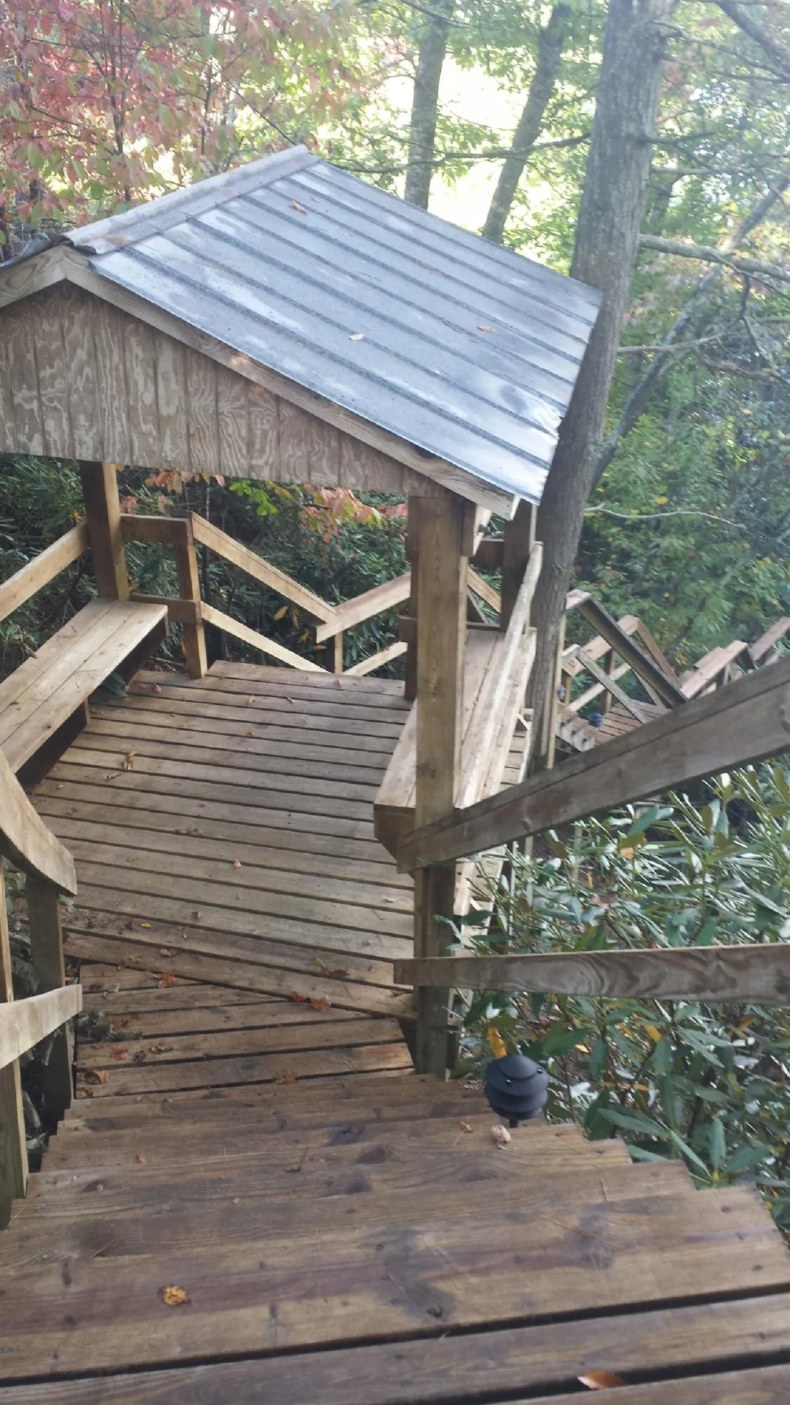 Metal roofed shelter over wooden steps on a wooded walkway — Skylight Repair & Installation work by our crew in Low Moor